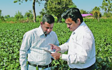 An employee of Bayer CropScience advising an indan farmer.